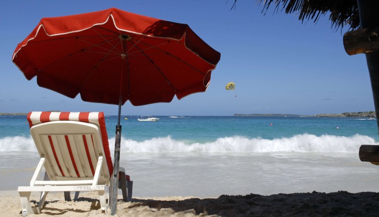 Urlaub am Strand mit Liegestuhl und Sonnenschirm